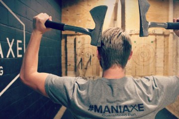 man throwing two axes